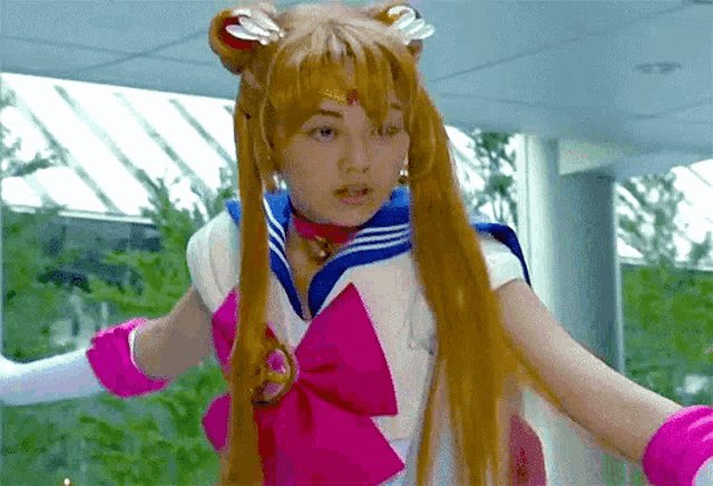 a woman in a sailor moon costume is standing with her arms outstretched
