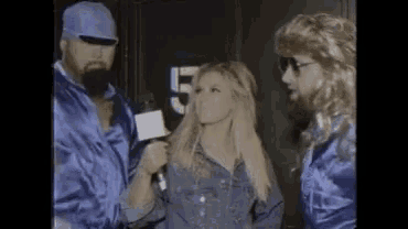a man with a beard is talking to a woman while standing next to two other women .