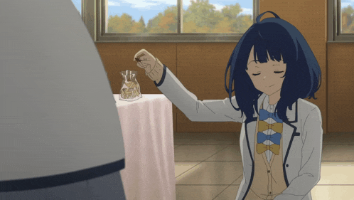 a girl with blue hair is holding something in her hand in front of a table cloth