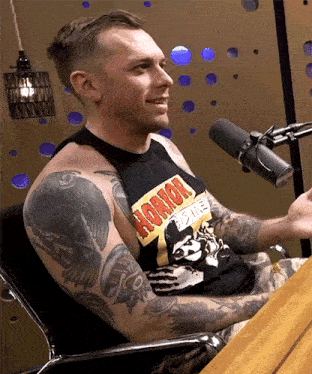 a man with tattoos is wearing a black tank top that says horror movie