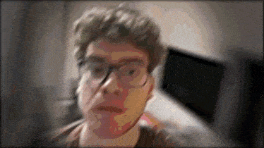 a blurry picture of a man 's face with glasses on