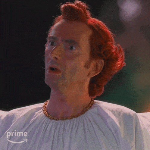 a man with red hair is wearing a white shirt with the word prime on it