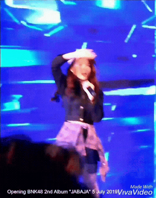 a woman singing into a microphone with the words " opening bnk48 2nd album " at the top