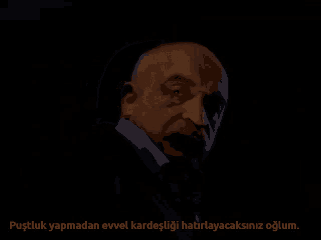 a man with a beard and mustache is shown in a dark room with a foreign language caption