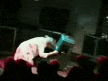 a man is sitting on a stage in front of a crowd