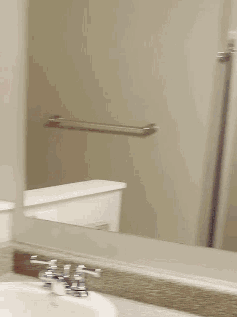 a blurry picture of a woman taking a selfie in a bathroom mirror