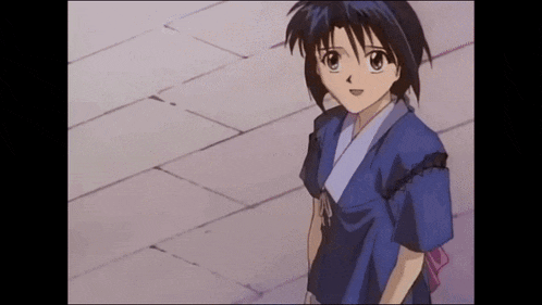 a young girl in a blue shirt is standing on a sidewalk .