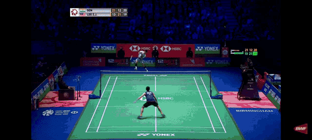 a badminton match is being played on a court with advertisements for yonex and hsbc