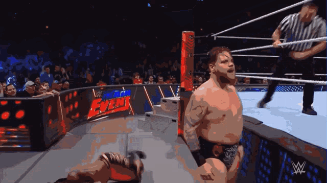 a man in a wrestling ring with a sign that says w on it