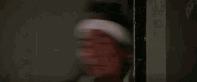 a blurry picture of a person holding a knife in a room .