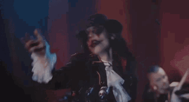 a man in a clown costume is standing in front of a microphone and singing into it .
