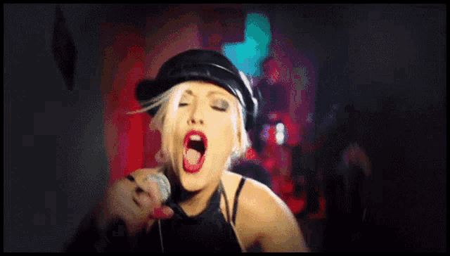a woman in a black top holds a microphone in her hand
