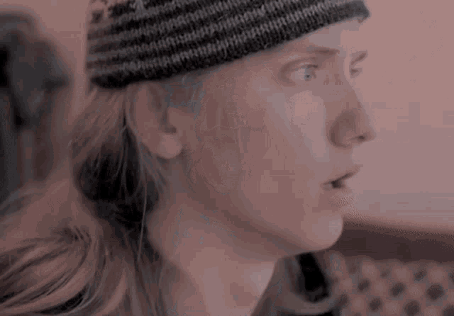a woman wearing a black and white striped hat looks surprised