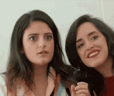 two women are making funny faces at the camera .