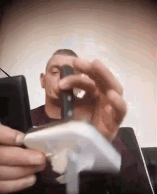 a man is holding a knife and a cell phone in his hand .