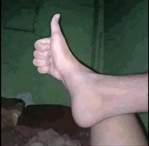 a person 's foot is giving a thumbs up sign .