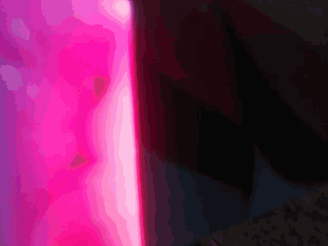 a close up of a pink light coming out of a bottle .