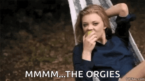 a woman is sitting in a hammock eating an apple and saying `` mmmm ... the orgies '' .