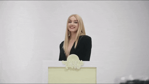 a woman stands behind a podium that says " wonderful world " on it