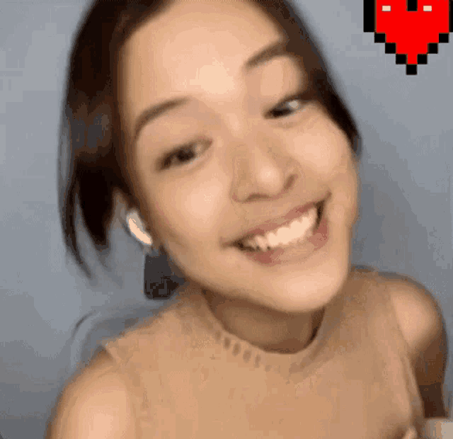 a close up of a woman 's face with a pixel heart behind her
