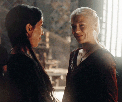 two women are looking at each other and smiling for the camera