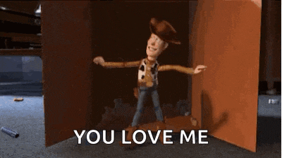 woody from toy story is standing in a box with the words `` you love me '' written on it .