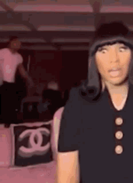 a woman in a black dress is standing in a room with a man in a white shirt .