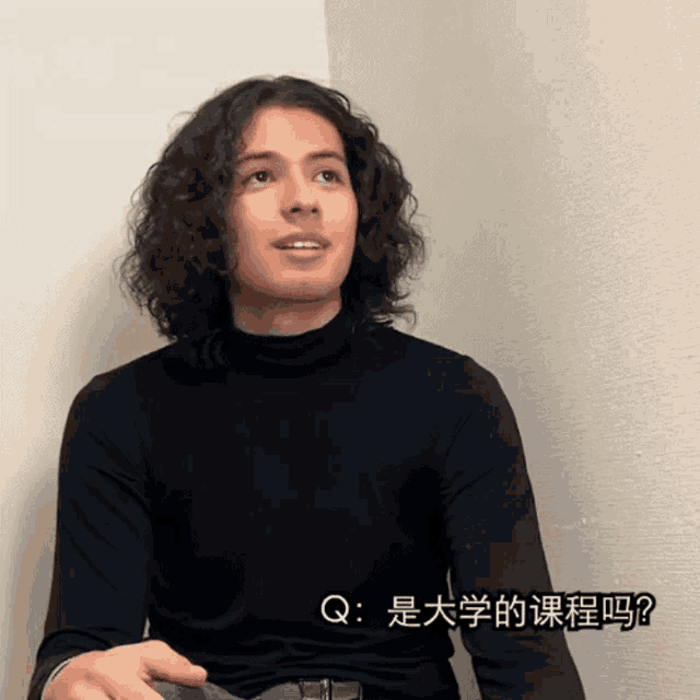 a man with long curly hair is wearing a black shirt