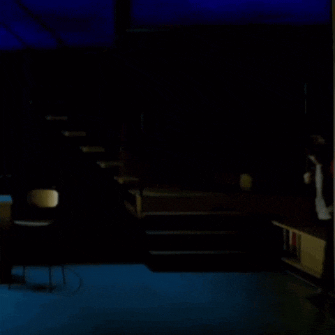a person walking in a dark room with blue lights