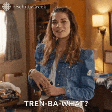 a woman in a denim jacket says tren-ba-what in a room