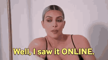 a woman in a black tank top is sitting on a bed and saying `` well , i saw it online . ''