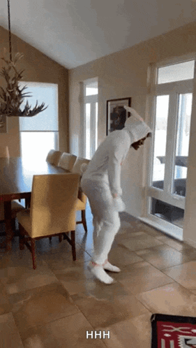 a person in a bunny costume is dancing in a room with the word hhh on the bottom