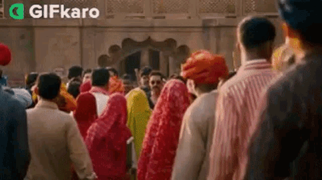 a crowd of people are standing in front of a building in india .