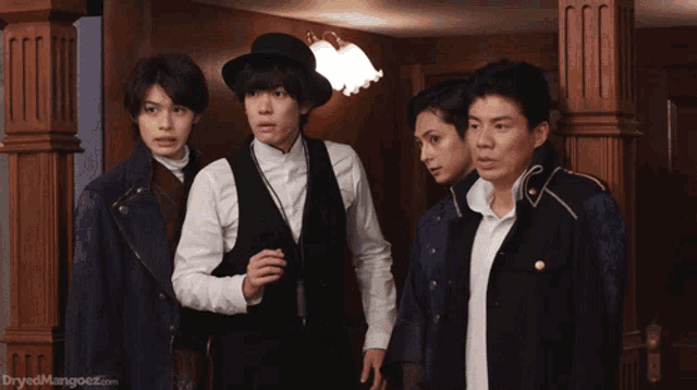 a group of men standing next to each other with the website dryedmangoez.com visible