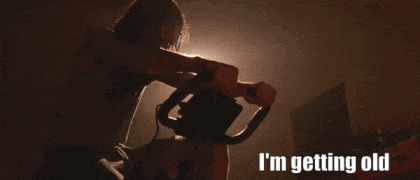 a man riding an exercise bike with the words " i 'm getting old " behind him