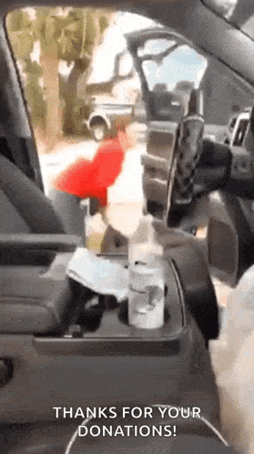a person is sitting in the driver 's seat of a car with a cup holder .