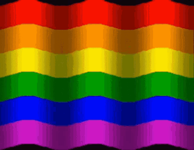 a rainbow flag is waving in the wind with a black background
