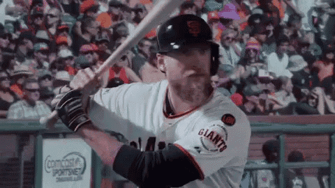 a baseball player is swinging a bat in front of a crowd at a baseball game .