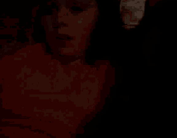 a close up of a woman 's face in a dark room .