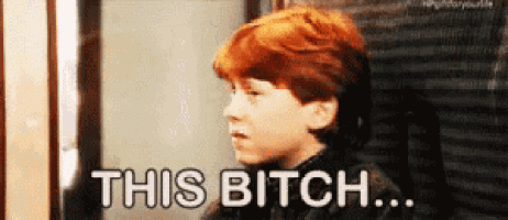 a young boy with red hair is standing in front of a sign that says this bitch .