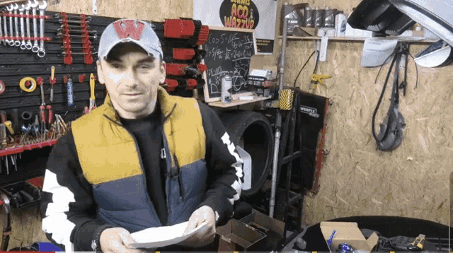 a man holding a plate in front of a sign that says aco wrap