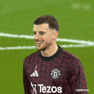 a man wearing a tezos jersey is smiling