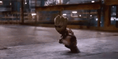 groot from guardians of the galaxy is sitting on the ground in a dark room .