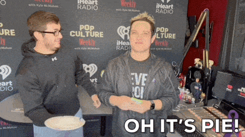 two men are standing in front of a wall that says iheart radio