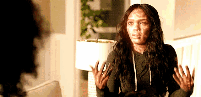 a woman with burns on her face is standing in a living room .