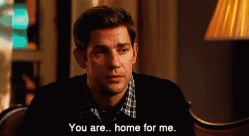 a man is sitting in a chair and talking to another man who is saying you are home for me .