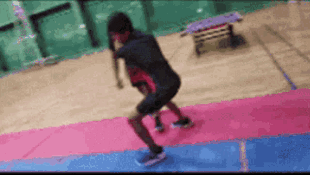 a blurred image of a person jumping on a mat