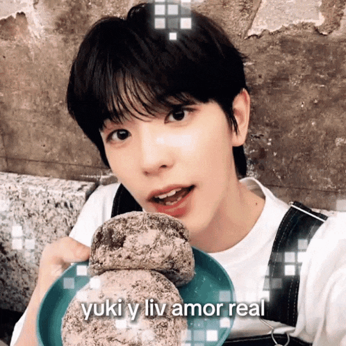 a young man is eating a stack of donuts with the words yuki y liv amor real above him