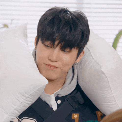 a person with a pillow on their head with the letter t on the front