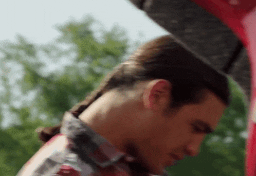a man in a plaid shirt is looking down